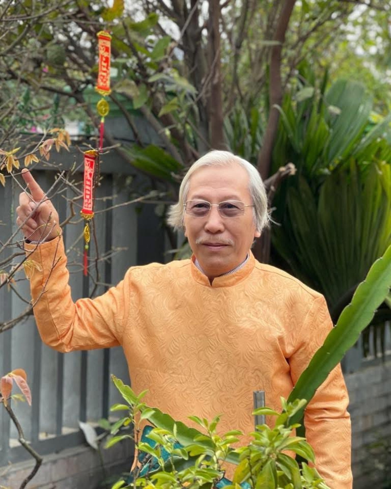 Chuyên gia phong thủy Hồ Thắng trong trang phục truyền thống màu cam